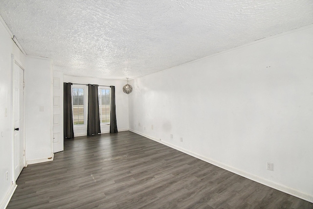 empty room featuring a textured ceiling, dark wood-style flooring, and baseboards