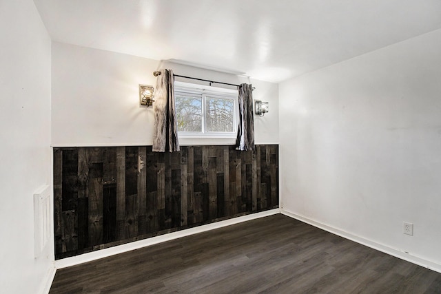 unfurnished room with baseboards and wood finished floors