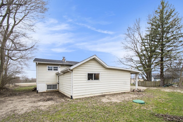 rear view of house with fence and a chimney