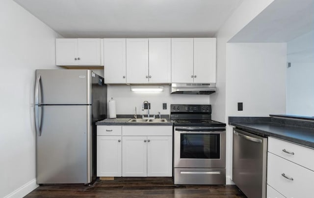 kitchen featuring white cabinets, under cabinet range hood, a sink, and appliances with stainless steel finishes