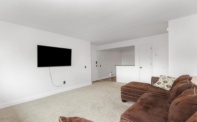 carpeted living room featuring baseboards
