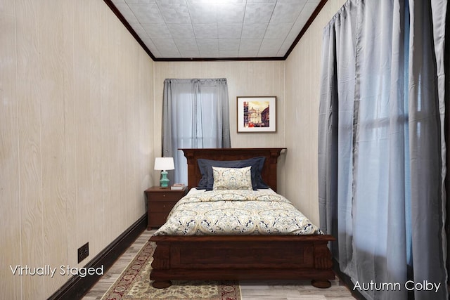 bedroom with wooden walls, ornamental molding, and wood finished floors