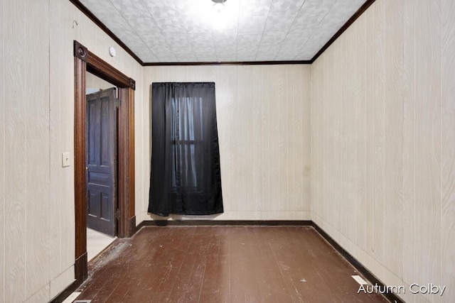 empty room featuring wood-type flooring and crown molding