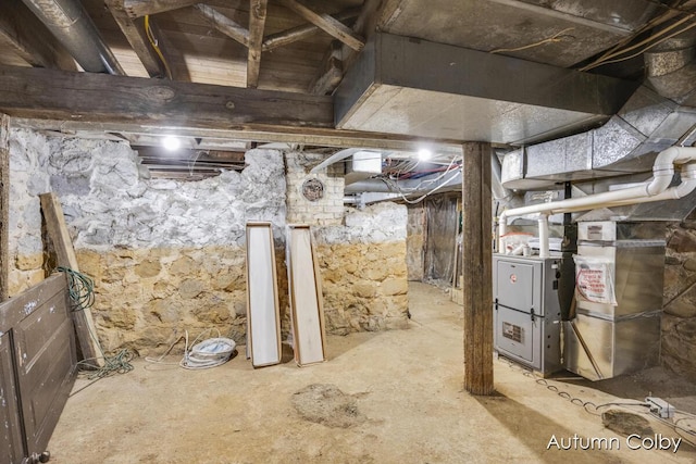 unfinished basement featuring heating unit