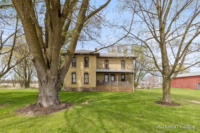 view of front facade featuring a front yard, a chimney, and covered porch
