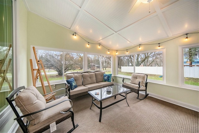 sunroom / solarium with a healthy amount of sunlight, baseboards, lofted ceiling with beams, and an outdoor hangout area