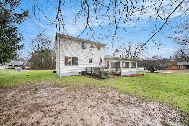 rear view of property featuring a sunroom and a lawn
