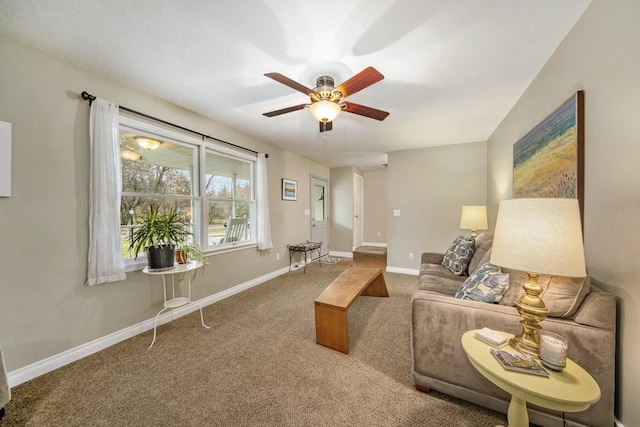 living area featuring carpet floors, ceiling fan, and baseboards