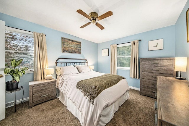 bedroom featuring dark colored carpet, baseboards, and a ceiling fan