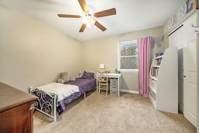 carpeted bedroom with ceiling fan and baseboards