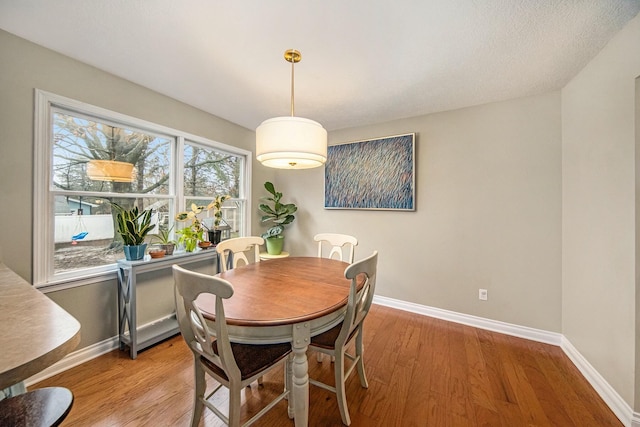dining area featuring baseboards and wood finished floors