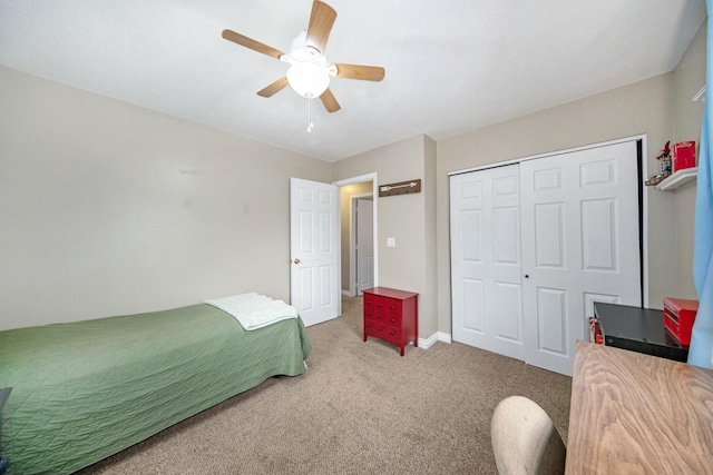 carpeted bedroom with a closet, baseboards, and ceiling fan
