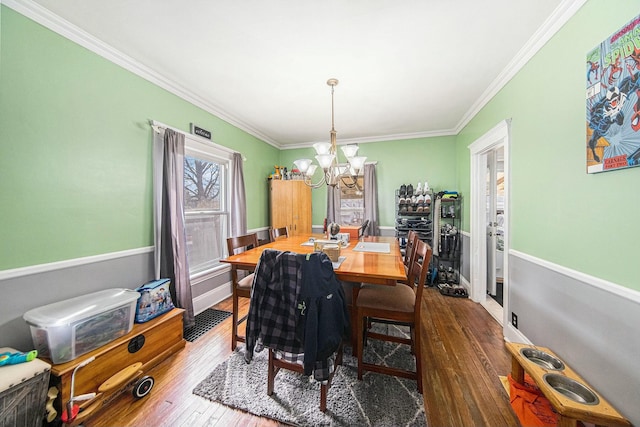 dining space featuring a chandelier, ornamental molding, and hardwood / wood-style flooring
