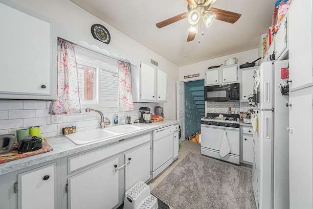 kitchen featuring a sink, ceiling fan, white appliances, white cabinetry, and decorative backsplash