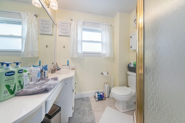 bathroom featuring baseboards, ornamental molding, toilet, vanity, and tile patterned flooring