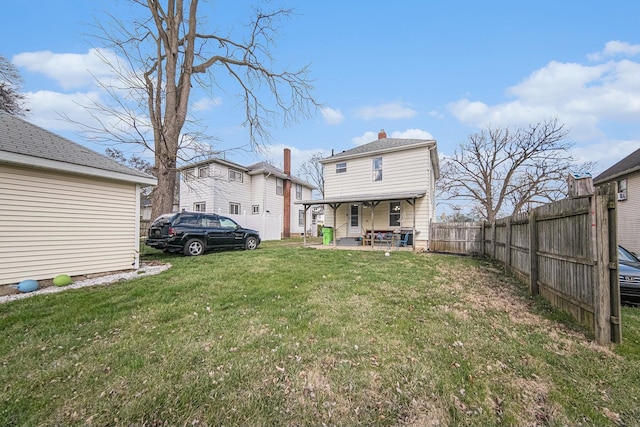 back of property with a yard and fence