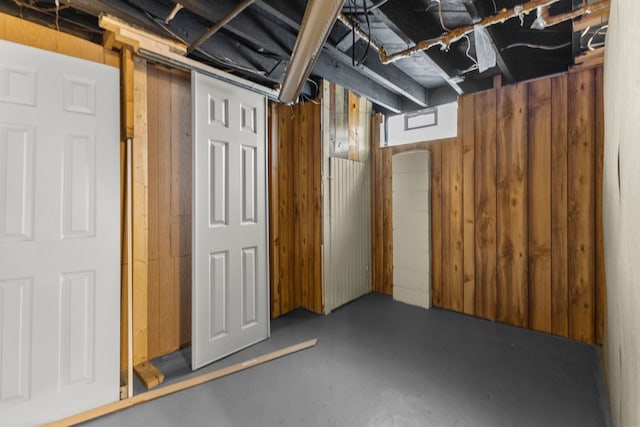 basement featuring wood walls
