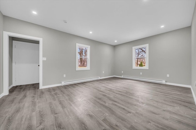 unfurnished room featuring baseboard heating, wood finished floors, and recessed lighting