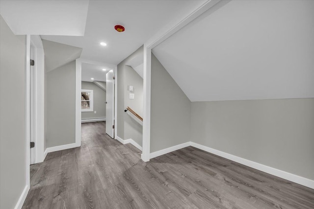 additional living space with wood finished floors, baseboards, vaulted ceiling, and recessed lighting