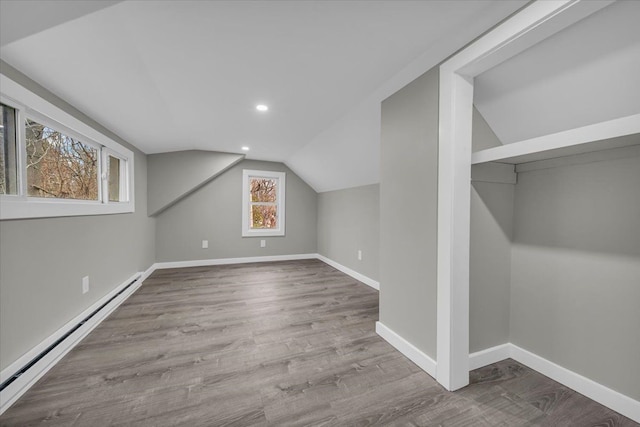 bonus room featuring baseboards, recessed lighting, lofted ceiling, a baseboard radiator, and wood finished floors