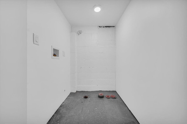 interior space featuring concrete flooring and concrete block wall