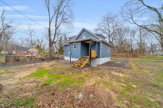 rear view of property with entry steps and fence