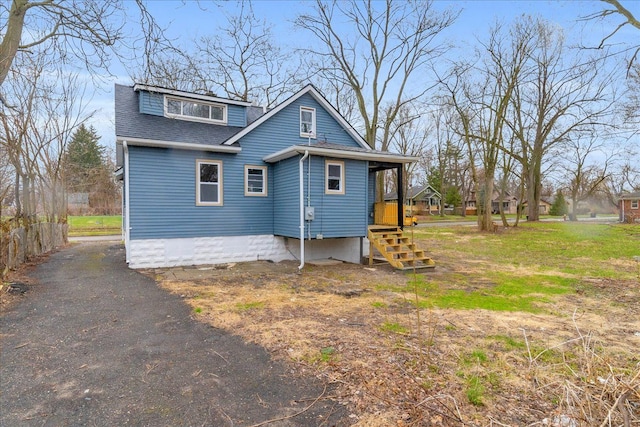 view of property exterior with aphalt driveway and a shingled roof
