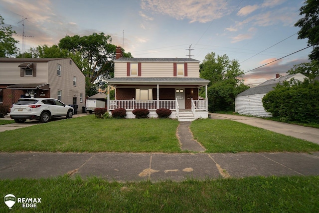 514 Chalmers St, Flint, MI 48503 - view of front facade featuring covered porch, a front yard, brick siding, and a chimney