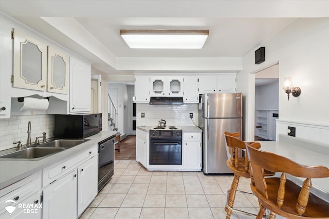 514 Chalmers St, Flint, MI 48503 - kitchen with black appliances, exhaust hood, a sink, tasteful backsplash, and white cabinets