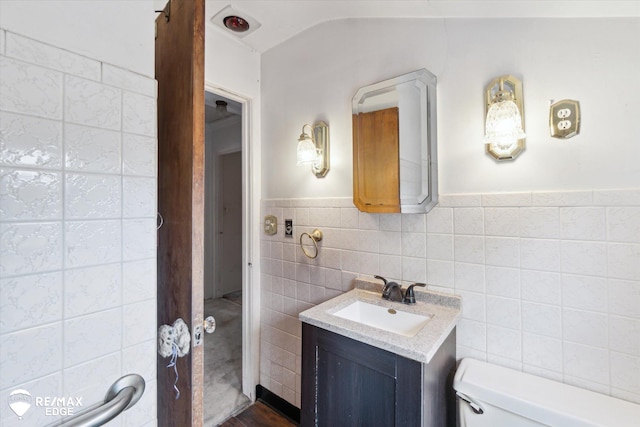 514 Chalmers St, Flint, MI 48503 - bathroom featuring tile walls, toilet, vanity, and a wainscoted wall