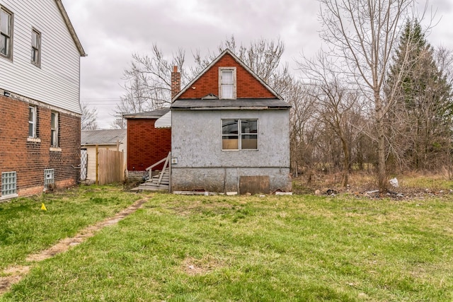 back of property with a yard and a chimney