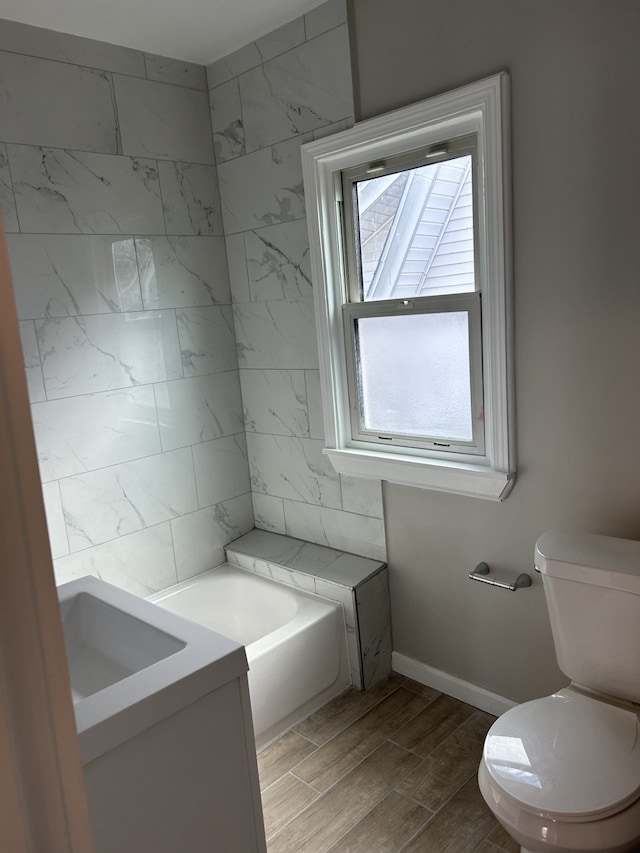 533 Lakewood St, Detroit, MI 48215 - bathroom with a bathing tub, toilet, a sink, wood tiled floor, and baseboards