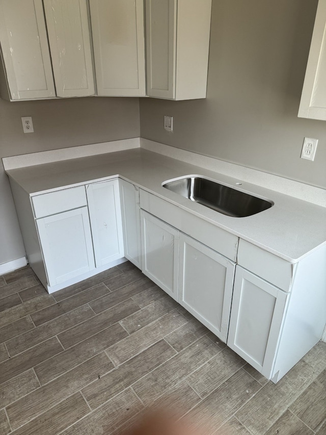 533 Lakewood St, Detroit, MI 48215 - kitchen featuring a sink, light countertops, white cabinets, and wood tiled floor