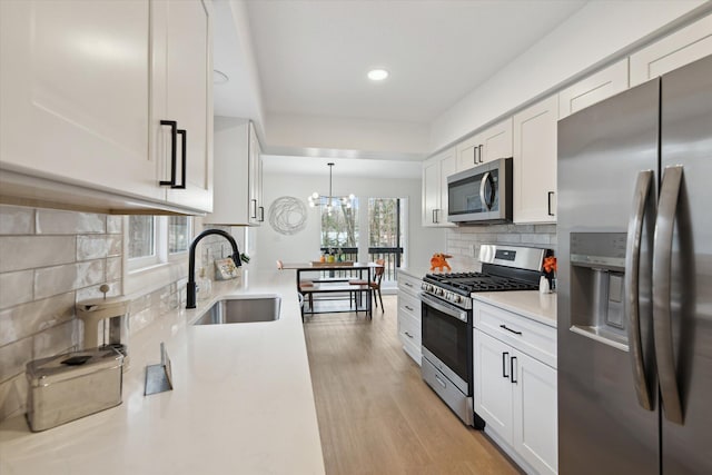 323 13th St, Plainwell, MI 49080 - kitchen with a sink, tasteful backsplash, appliances with stainless steel finishes, and white cabinetry