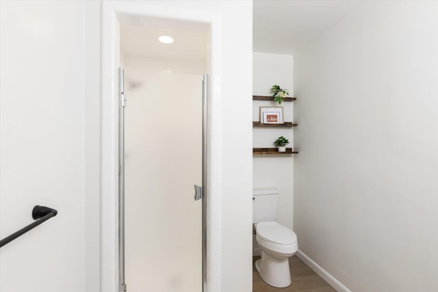 323 13th St, Plainwell, MI 49080 - bathroom with toilet, a shower stall, wood finished floors, and baseboards