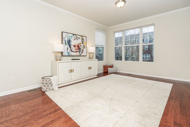 unfurnished room with crown molding, visible vents, baseboards, and dark wood finished floors