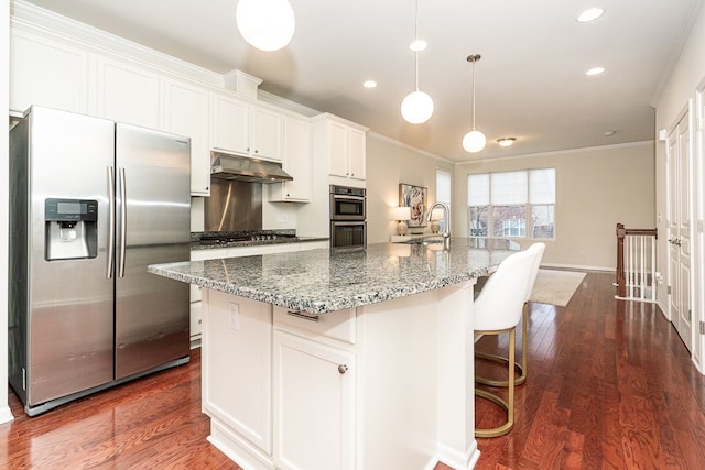kitchen with a sink, ornamental molding, an island with sink, under cabinet range hood, and stainless steel appliances