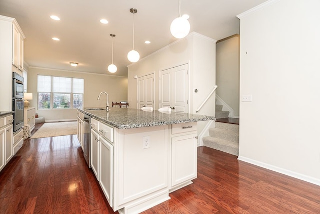 kitchen with a sink, appliances with stainless steel finishes, crown molding, and dark wood-style floors