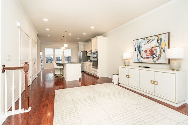 interior space featuring crown molding, dark wood finished floors, a kitchen bar, recessed lighting, and stainless steel appliances