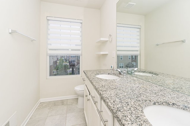 full bath featuring a sink, toilet, double vanity, and plenty of natural light