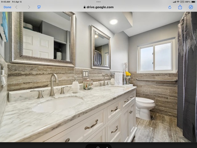 27908 Ryan Rd, Warren, MI 48092 - full bathroom featuring tile walls, toilet, double vanity, and a wainscoted wall