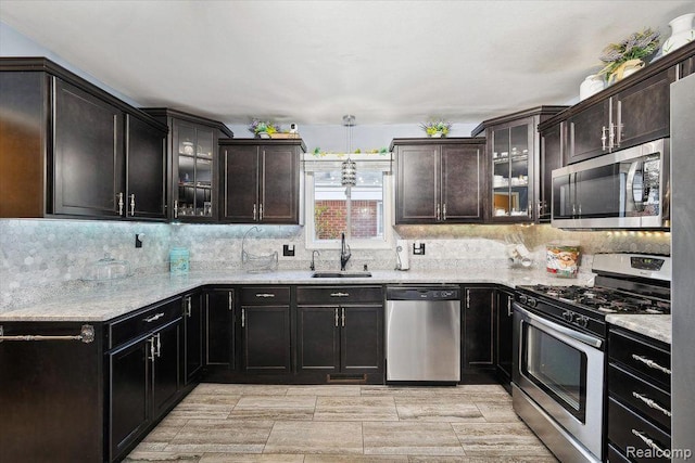 27908 Ryan Rd, Warren, MI 48092 - kitchen with appliances with stainless steel finishes, decorative backsplash, and glass insert cabinets