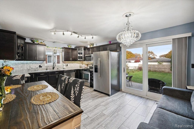 27908 Ryan Rd, Warren, MI 48092 - kitchen featuring stainless steel appliances, a chandelier, backsplash, glass insert cabinets, and dark brown cabinets
