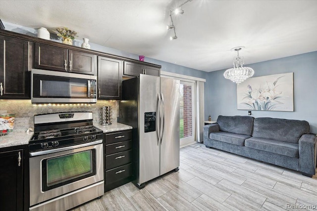 27908 Ryan Rd, Warren, MI 48092 - kitchen with stainless steel appliances, tasteful backsplash, a chandelier, open floor plan, and wood tiled floors