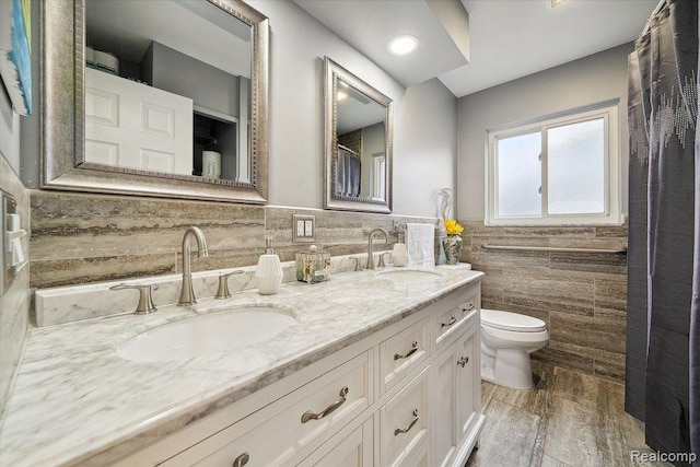 27908 Ryan Rd, Warren, MI 48092 - full bath featuring tile walls, double vanity, wood finished floors, and wainscoting