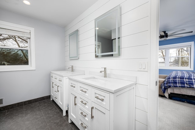 ensuite bathroom with baseboards, a ceiling fan, ensuite bath, vanity, and tile patterned floors
