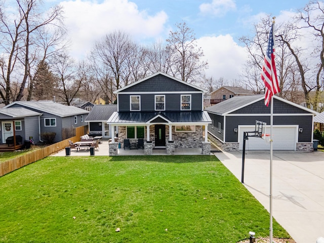 view of front of house featuring a standing seam roof, a front yard, fence, stone siding, and a garage