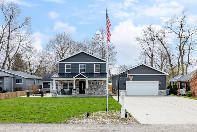 view of front facade featuring a detached garage, stone siding, a front lawn, a porch, and fence