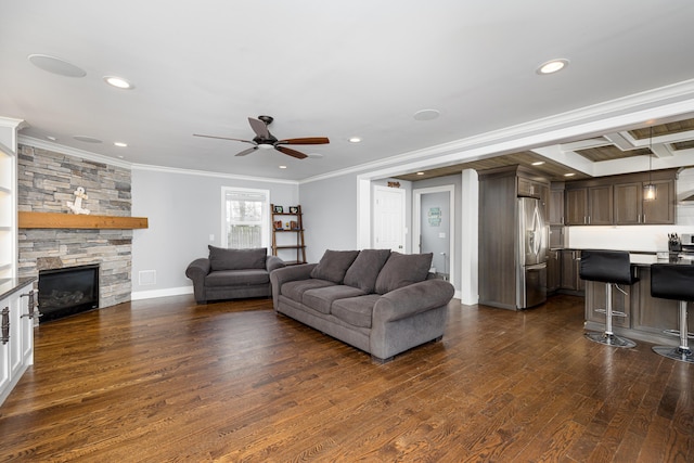 living room featuring a ceiling fan, ornamental molding, a fireplace, and dark wood-style floors