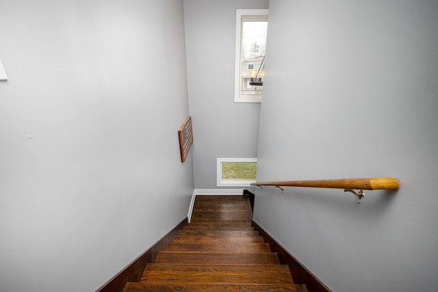 stairway with plenty of natural light, visible vents, baseboards, and wood finished floors